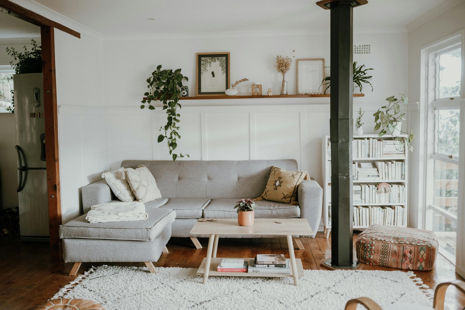 Bright Scandinavian-style living room with soft neutral seating, natural textures, and tall windows.